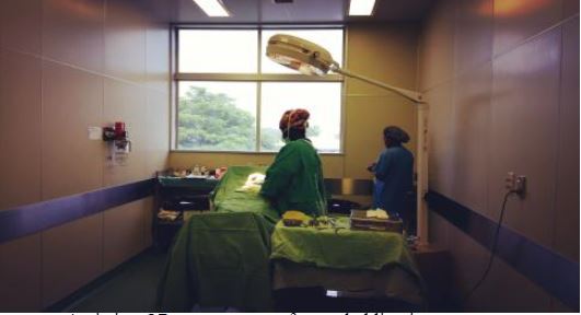 Assisting OR nurses set up for a tubal ligation surgery